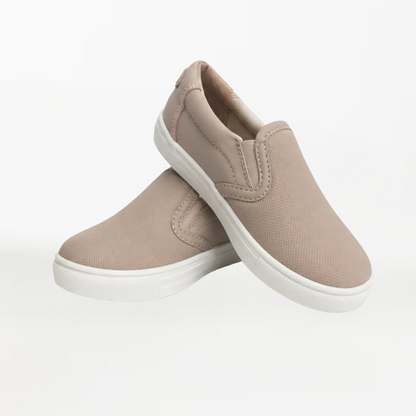 A pair of slip-on canvas sneakers in a light taupe-beige color with white soles, displayed against a clean white background.