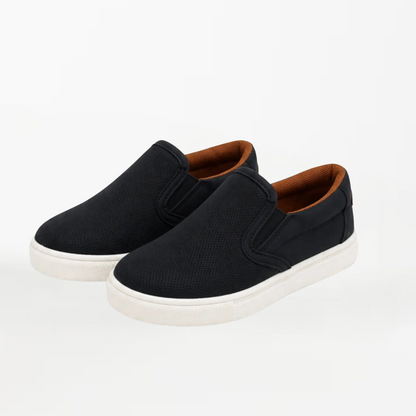 A pair of black slip-on canvas sneakers with brown lining and white soles, photographed on a clean white background.